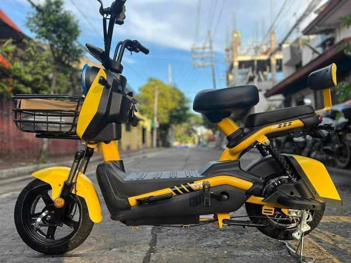 Electric Scooter E-Bike with Basket and Backrest (Category: Bicycles) located in Manila. Submitted by idealtoys (Listing ID 1467862759, Image 1). Description: - Electric scooter with functional front wire basket - Dual seating setup with padded rear passenger seat and backrest support - Integrated pedals included for hybrid manual riding - Stable center kickstand setup for easy parking - Handlebars wrapped in protective plastic - Available colorw