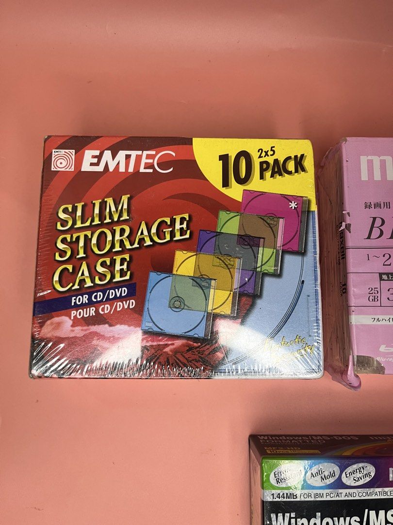 EMTEC CD/DVD Slim Cases & Maxell Discs Bundle (Category: CDs & DVDs) located in Caloocan City. Submitted by snapshop_ph (Listing ID 1467871771, Image 2). Description: Bundle includes three packs. EMTEC 10-pack slim storage cases for CDs and DVDs in various transparent colors. Maxell BD-RE 10-pack 25GB floral pink rewriteable Blu-ray discs, 3 hours recording time. Maxell Windows/MS-DOS formatted 2HD floppy disks 10-pack with plastic case. All boxe
