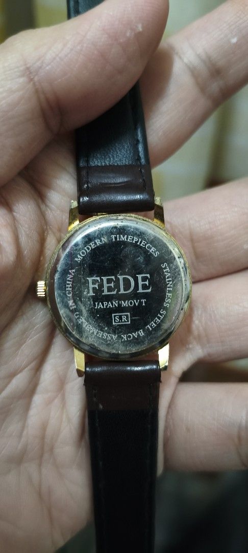 FEDE Quartz Watch with Brown Leather Strap (Category: Women's Watches) located in Quezon City. Submitted by gemaicloset (Listing ID 1468017770, Image 2). Description: - Brand: FEDE Quartz Watch - Dial: Round cream-colored with black numbers and 24-hour inner ring Japan source - Case: Elegant gold-tone with stainless steel back - Strap: Dark brown stitched leather with standard buckle closure - Movement: Japan movement, assembled in China - Condit