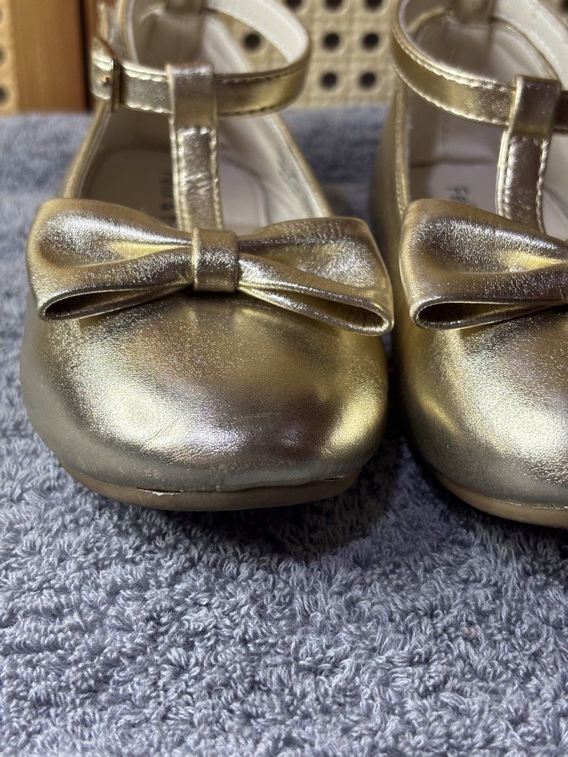 Felix & Flora Gold T-Bar Flats with Bow (Category: Babies & Kids Fashion) located in Manila. Submitted by wardrobeinmnl (Listing ID 1467892049, Image 3). Description: Size: 10 - Brand: Felix & Flora - Color/Finish: Gold metallic - Design: T-bar strap with buckle closure and cute toe bow - Condition: Clean insoles and neat stitching - Versatile: Great for parties, weddings, or everyday wear.