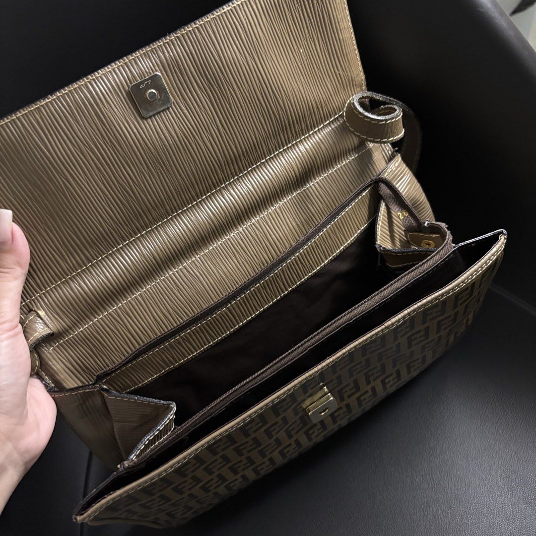 Fendi Monogram PVC Clutch Bag (Category: Luxury Bags & Wallets) located in Makati City. Submitted by dianedelro (Listing ID 1467937694, Image 3). Description: - Authentic vintage Fendi - Structured flap closure featuring taupe trim and a metal Fendi logo plaque - Adjustable leather strap for comfortable wear - Spacious brown fabric-lined interior with a secure zipped pocket - Includes the authentic gold Fendi S.A.S. stamp label - Timeless everyda