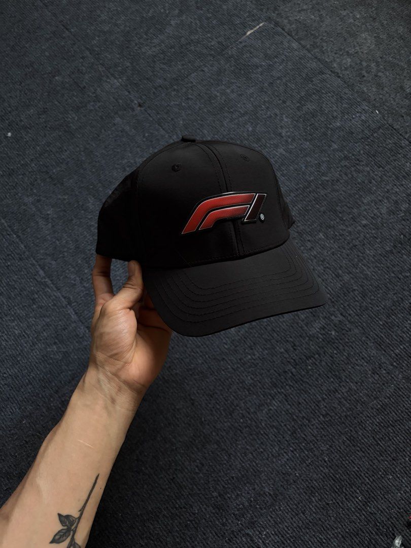 Formula 1 Black F1 Snapback Cap Hat (Category: Caps & Hats) located in Manila. Submitted by toys_hats005 (Listing ID 1467957118, Image 1). Description: - Official Formula 1 merchandise - Color: Classic black with striking red accents - Bold red rubberized F1 logo on the front - "FORMULA 1" embroidered in red on the back strap - Adjustable plastic snap closure for a custom fit - Lightweight, breathable material for all-day comfort - Branded interi