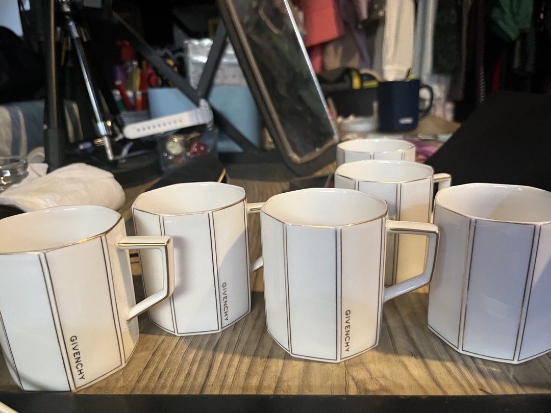 Givenchy White and Gold Geometric Mugs Set (Category: Coffee & Tea Tableware) located in Malabon City. Submitted by mgsurplus (Listing ID 1467933631, Image 1). Description: -6pcs - Brand: Givenchy - Material: Premium ceramic - Design: White finish with gold vertical stripes, gold rim trim, and distinct vertical Givenchy logo - Shape: Modern geometric faceted design with comfortable angular handles - Condition: Clean appearance with 100% intact go