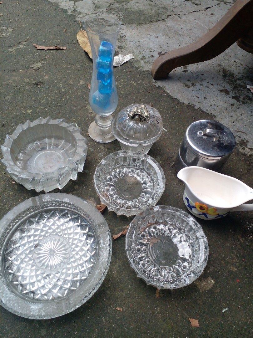 Glass ashtrays vase pitcher canister bundle (Category: Vases & Decorative Bowls) located in Quezon City. Submitted by madelrivera (Listing ID 1467998806, Image 2). Description: Bundle of assorted glass items, ceramic pitcher, and stainless steel canister. Includes several glass ashtrays with different patterns, a tall glass vase filled with blue glass stones, lidded jar, painted ceramic gravy boat, and metal container with lid. Everything sold to