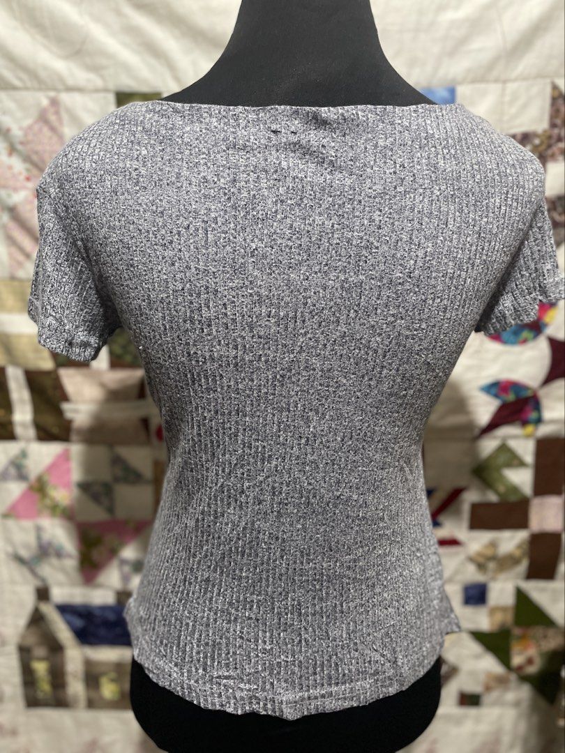 Gray Asymmetrical Button-Front Ribbed Knit Top (Fits Medium) (Category: Blouses) located in Roxas City. Submitted by budgetfindsroxasph (Listing ID 1467932295, Image 3). Description: Elevate your casual outfit with this unique gray ribbed knit top! It features an asymmetrical diagonal button detail down the front and a flattering angular pointed hem line. Made from soft, stretchy ribbed knit fabric for maximum comfort and style. Fits Medium.