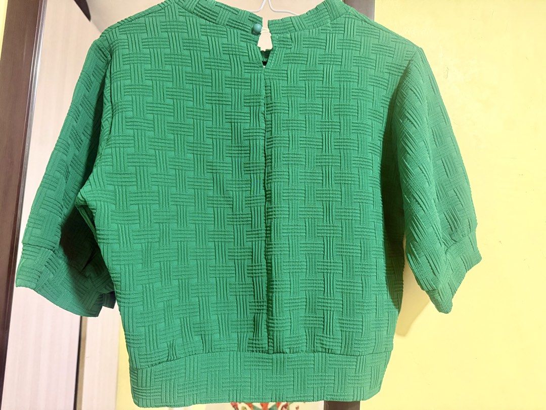 Green Textured Short Sleeve Top with Back Button and Side Zip (Category: Shirts) located in Manila. Submitted by rrtolibas48132 (Listing ID 1467962771, Image 2). Description: - Color: Vibrant bright green - Design: All-over textured woven pattern - Sleeves: Short sleeves with gathered cuffs - Neckline: Round neck with a back keyhole and button closure - Closure: Convenient side zipper for easy wear - Fit: Cropped length with a stylish wide hem ba