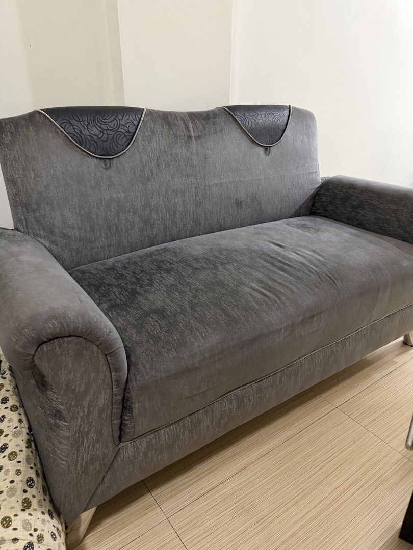 Grey 2-Seater Velvet Fabric Sofa with Patterned Headrests (Category: Sofas) located in Paranaque City. Submitted by captainthanos01 (Listing ID 1467897092, Image 1). Description: - Grey 2-seater sofa ideal for living rooms or studio apartments - Soft textured fabric finish in a clean, versatile grey tone - Features supportive back cushions, structured armrests, and standard seating height/depth - Stylish dark patterned panels on the upper backres