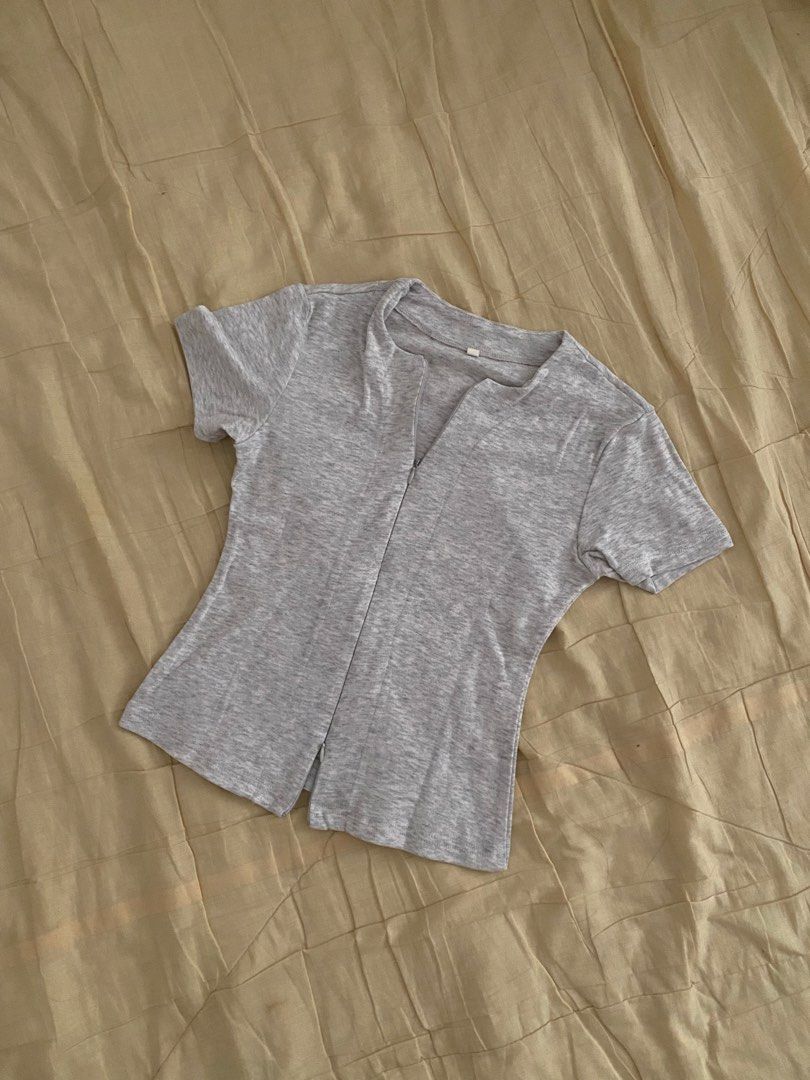 Grey Short Sleeve Top with Front Zip (Category: Blouses) located in Taguig. Submitted by blckprl_22 (Listing ID 1467856371, Image 1). Description: - Color: Grey - Material: Soft ribbed knit - Size: Small (worn twice) - Features: Front zipper closure, split hem detail, and scoop neckline - Sleeves: Short sleeves - Condition: Excellent, clean, no stains or damage - Sizing: Standard sizing label attached Location: Taguig 📍.