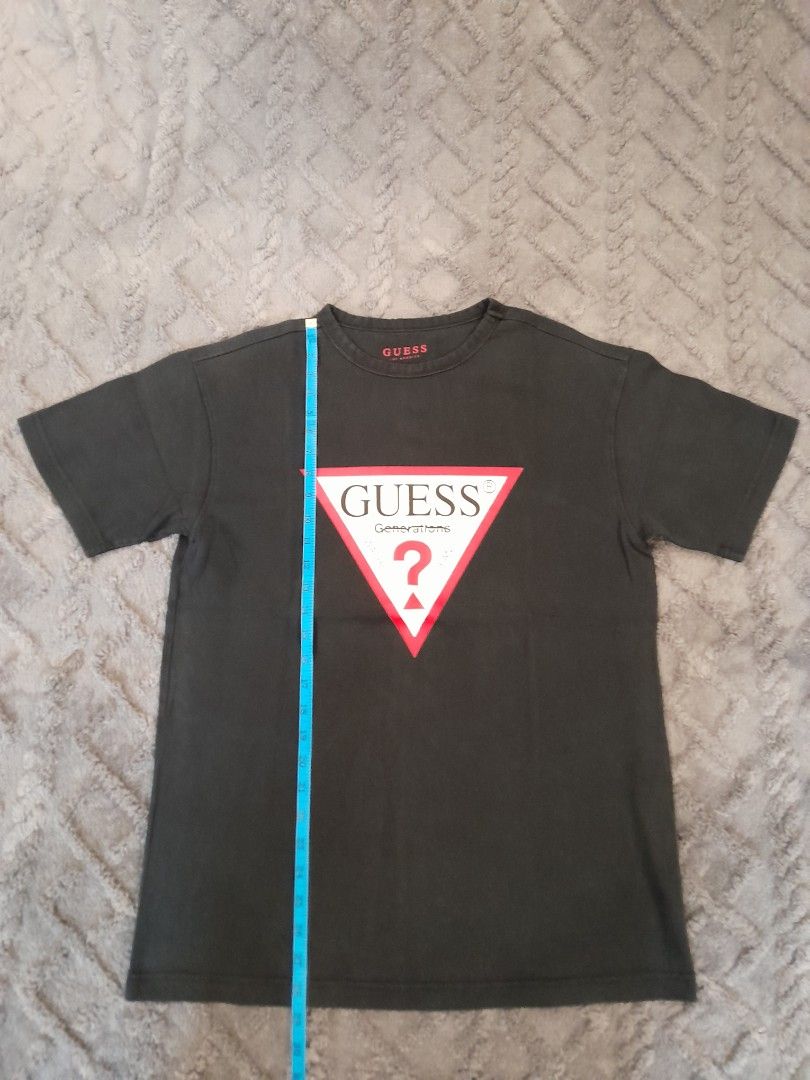 Guess Generations Logo T-Shirt Black (Category: Tshirts & Polo Shirts ) located in Las Pinas. Submitted by maljun1972 (Listing ID 1467927086, Image 2). Description: - Brand: Guess - Style: Short-sleeve crew neck t-shirt with standard fit - Color: Black - Design: Iconic triangular Guess Generations logo on the chest, subtle branding inside the collar - Material: Soft, comfortable cotton fabric - Measurements: Approximately 20.5 inches across the c