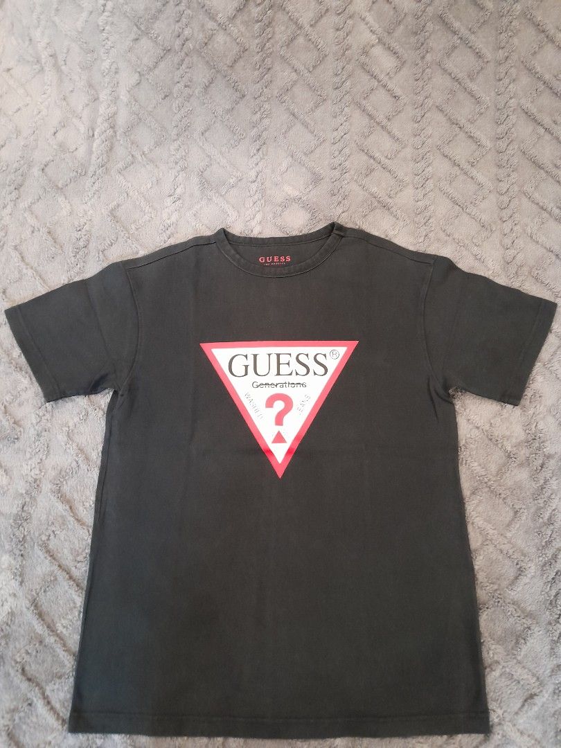 Guess Generations Logo T-Shirt Black (Category: Tshirts & Polo Shirts ) located in Las Pinas. Submitted by maljun1972 (Listing ID 1467927086, Image 1). Description: - Brand: Guess - Style: Short-sleeve crew neck t-shirt with standard fit - Color: Black - Design: Iconic triangular Guess Generations logo on the chest, subtle branding inside the collar - Material: Soft, comfortable cotton fabric - Measurements: Approximately 20.5 inches across the c