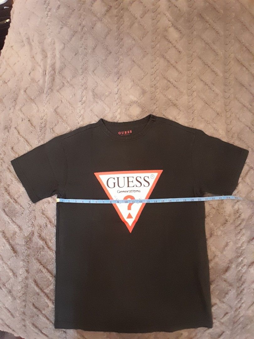 Guess Generations Logo T-Shirt Black (Category: Tshirts & Polo Shirts ) located in Las Pinas. Submitted by maljun1972 (Listing ID 1467927086, Image 3). Description: - Brand: Guess - Style: Short-sleeve crew neck t-shirt with standard fit - Color: Black - Design: Iconic triangular Guess Generations logo on the chest, subtle branding inside the collar - Material: Soft, comfortable cotton fabric - Measurements: Approximately 20.5 inches across the c