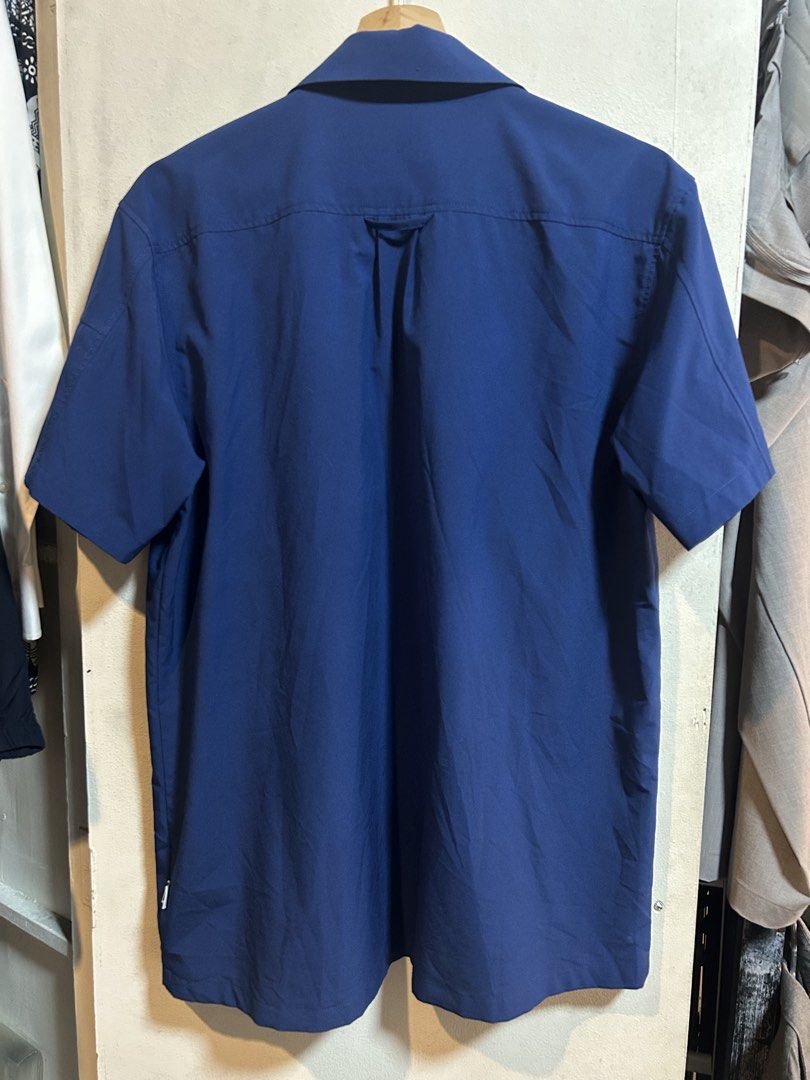 Helly Hansen Blue Short Sleeve Button Down Shirt M (Category: Tshirts & Polo Shirts ) located in Manila. Submitted by popluxeph_ (Listing ID 1468046776, Image 3). Description: - Brand/Model: Helly Hansen Norway (Since 1877) - Color: Blue with green inner collar lining - Size: Medium - Features: Chest flap pockets and an extra zip pocket on the left sleeve - Material: Lightweight fabric, ideal for outdoor activities or casual wear.