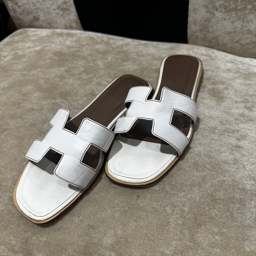Hermes Oran White Leather Sandals Size 38 (Category: Flats & Sandals) located in Quezon City. Submitted by retroboominwantsummoh (Listing ID 1467966162, Image 1). Description: - Brand: Hermes - Style: Iconic H strap sandals - Color: White leather with brown insoles - Size: 38 (Made in Italy) - Condition: Leather uppers are clean with minimal creasing; soles show visible dirt and scuffing from previous wear - Perfect for adding effortless luxury t