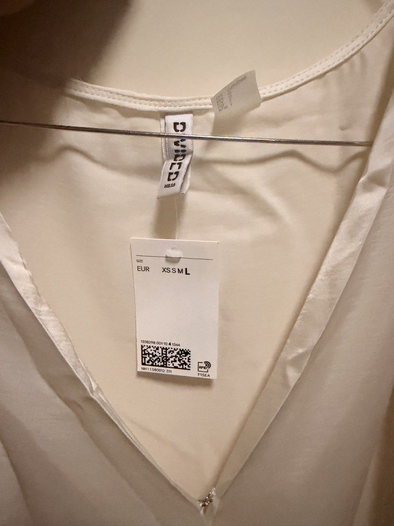 H&M Divided White Wrap Dress with Side Bow (Category: Dresses) located in Candelaria. Submitted by thv_bibi (Listing ID 1468009550, Image 2). Description: - Brand: H&M Divided - Style: Sleeveless white wrap dress with V-neck and pleated shoulder details - Material: Silky satin-like finish - Extras: Includes a matching side tie belt with a bow detail - Condition: Brand new with original store tag attached - Sizing: EUR sizing Original price: 1490 