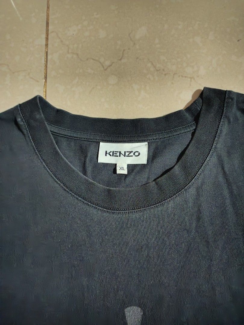 Kenzo Paris Eye Graphic Black Tee (Category: Tshirts & Polo Shirts ) located in Lapu Lapu. Submitted by rebuild.arkives (Listing ID 1467930671, Image 3). Description: Kenzo Paris Eye Graphic Black Tee ‎ ‎📏 Size Guide (Inches): ‎Length - 30 ‎Width - 22 ‎ ‎Color: 10/10 ‎Condition: 9/10 ‎Issue: A little pinhole ‎ ‎📝 Heads up: ‎• This is a thrift item so please manage your expectations. ‎• Color may slightly differ due to lighting. ‎• Washed and re