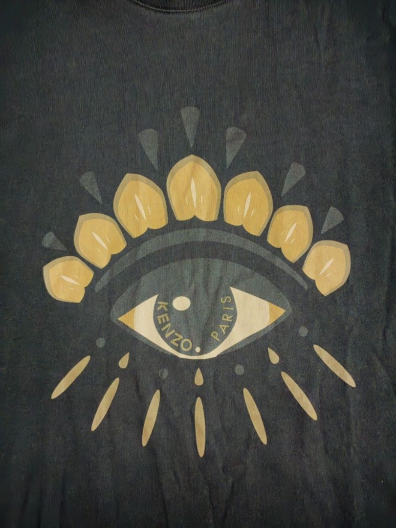 Kenzo Paris Eye Graphic Black Tee (Category: Tshirts & Polo Shirts ) located in Lapu Lapu. Submitted by rebuild.arkives (Listing ID 1467930671, Image 2). Description: Kenzo Paris Eye Graphic Black Tee ‎ ‎📏 Size Guide (Inches): ‎Length - 30 ‎Width - 22 ‎ ‎Color: 10/10 ‎Condition: 9/10 ‎Issue: A little pinhole ‎ ‎📝 Heads up: ‎• This is a thrift item so please manage your expectations. ‎• Color may slightly differ due to lighting. ‎• Washed and re