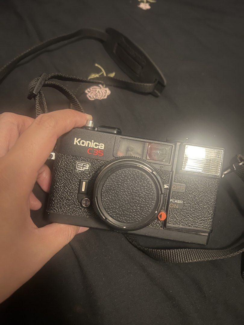 Konica C35 EF 35mm Film Camera with Strap (Category: Cameras) located in Marikina City. Submitted by yelsellsthings (Listing ID 1468052438, Image 1). Description: - Model: Konica C35 EF 35mm compact film camera - Color: Classic black body with textured grip - Features: Built-in electronic flash, clear viewfinder, and smooth film advance dial Condition: Not actually sure if flash is still working but may sound na nagchcharge like how it was so idk