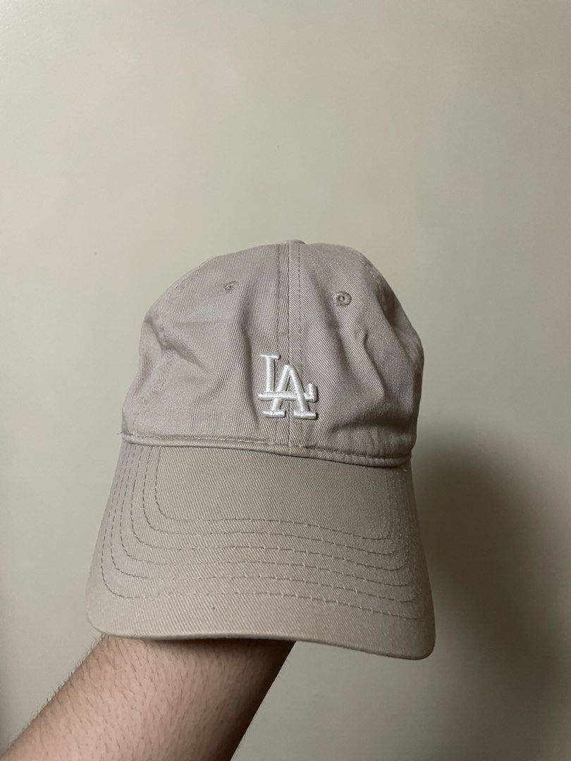 LA Dodgers Cap (Category: Caps & Hats) located in Pasig City. Submitted by randomclothes_ (Listing ID 1467949437, Image 1). Description: - Authentic MLB LA Dodgers baseball cap - Color: Beige with white embroidered LA logo - Classic curved brim and adjustable strap for a custom fit - Official Major League Baseball tag included - Clean fabric, 100% stain-free and undamaged.