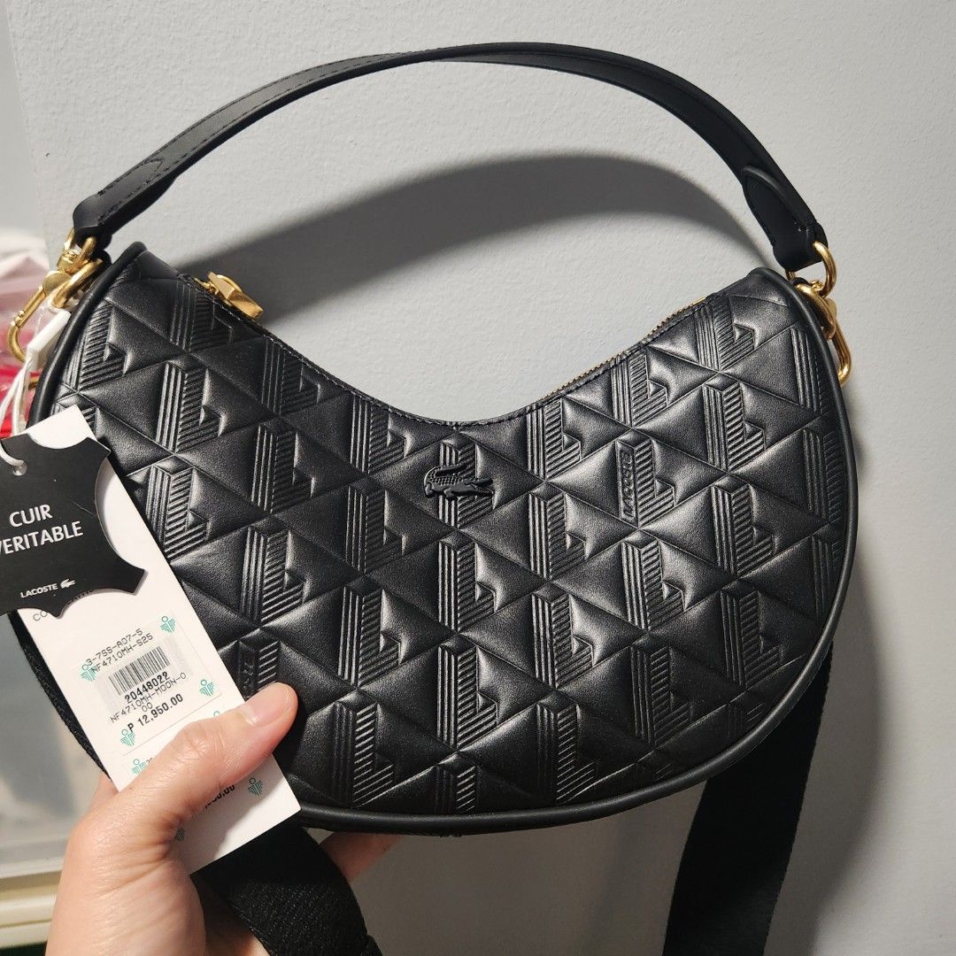Lacoste Black Leather Moon Bag NF4710MH (Category: Luxury Bags & Wallets) located in Pasay City. Submitted by dqueen28 (Listing ID 1468004564, Image 1). Description: - Brand: Lacoste - Style: Crescent shoulder bag in black leather - Design: Chic geometric embossed pattern with premium gold-tone hardware - Condition: Brand new with original hang tags and genuine leather sample label - Retail Price: ₱12,950.00 - Straps: Includes a short leather str