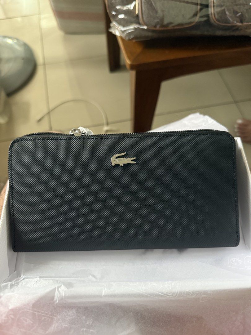Lacoste Black Zip Around Wallet (Category: Wallets & Card holders) located in Manila. Submitted by kcirtapoabmir (Listing ID 1467900736, Image 1). Description: - Stylish black zip-around wallet with a textured pattern - Features a striking silver-tone crocodile logo in the center - Spacious interior with plenty of slots for cards and cash - High-quality construction with clean stitching all around - Comes brand new in its original white box.
