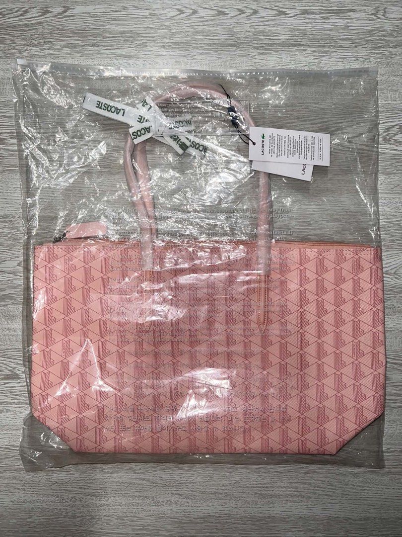 Lacoste Pink Geometric Tote Bag (Category: Tote Bags) located in Quezon City. Submitted by callist0 (Listing ID 1467980611, Image 2). Description: Pink Lacoste tote bag with a geometric monogram pattern throughout. Dual shoulder straps, top zipper closure, and front logo text with crocodile emblem. Tags still attached, packed inside the original clear plastic bag. price is firm. Location: San Juan, Metro Manila NO REFUND POLICY.
