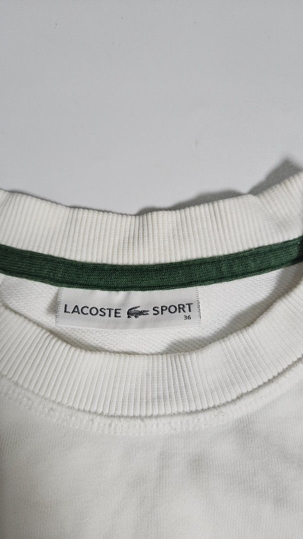 Lacoste Sport White Sweatshirt Size 36 (Category: Coats, Jackets and Outerwear) located in Alfonso. Submitted by jbcamet (Listing ID 1467980797, Image 3). Description: - Brand: Lacoste Sport - Style: White crewneck sweatshirt - Size: 36 (Tag on collar) - Material: Comfortable cotton fleece - Details: Iconic green interior collar lining and small embroidered crocodile logo on the chest - Finishing: Ribbed cuffs, hem, and collar for a snug fit - Co