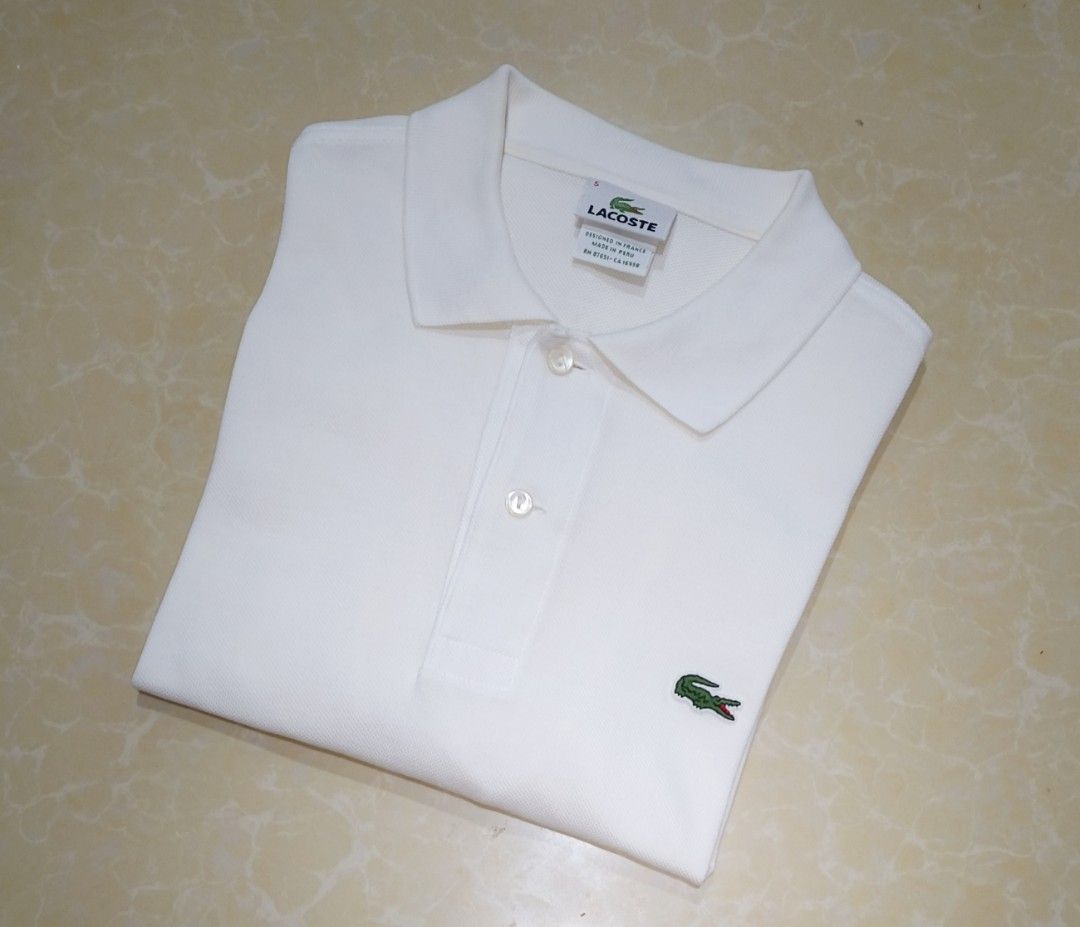 Lacoste White Polo Shirt Size 5 (Category: Tshirts & Polo Shirts ) located in Manila. Submitted by purefire-477a (Listing ID 1467852336, Image 3). Description: - Brand: Lacoste - Color: White - Size: 5 (Roughly 20.5" width x 28" length) - Details: Classic two-button placket with mother-of-pearl buttons, ribbed collar and armbands - Logo: Iconic embroidered green crocodile on the left chest - Origin: Designed in France, made in Peru - Condition: C