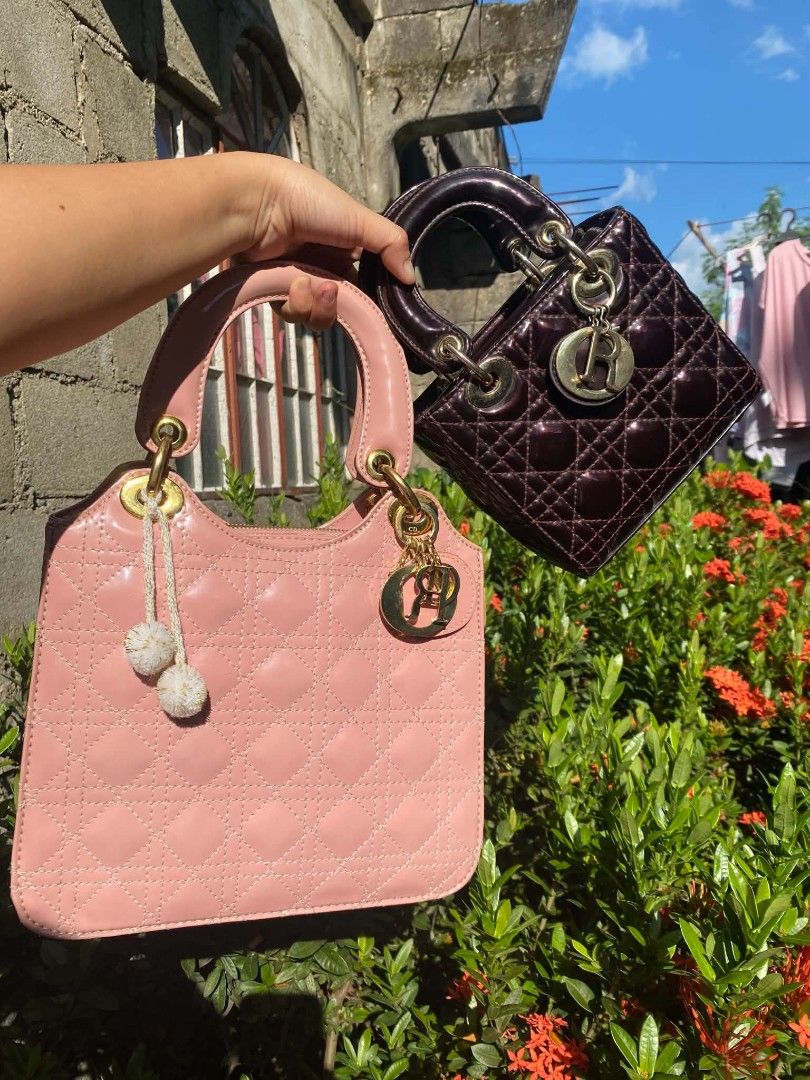 LADY DIOR set (Category: Tote Bags) located in Guiset East. Submitted by aprilrosec37142 (Listing ID 1467945817, Image 1). Description: - Set of 2 stylish quilted handbags available individually or together - Option 1: Glossy pink finish with double pom-pom charm and gold hardware - Option 2: Dark metallic purple with a chic hanging letter charm - Features structured top handles and timeless quilted stitching - Perfect size for daily essentials, 