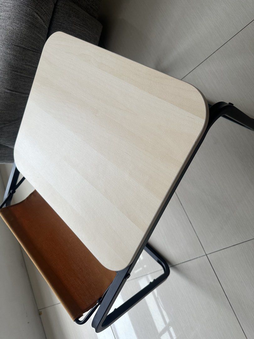 IKEA OLSERÖD Side table / Laptop / coffee table dual height with catch tray (Category: Tables & Sets) located in Quezon City. Submitted by dlsy12 (Listing ID 1467930624, Image 2). Description: - Compact accent table with a stylish light wood-grain top and sturdy black metal frame - Features a built-in brown fabric sling pocket at the back for storing magazines and small items - Ideal for small spaces in the living room, bedroom, or study area - C