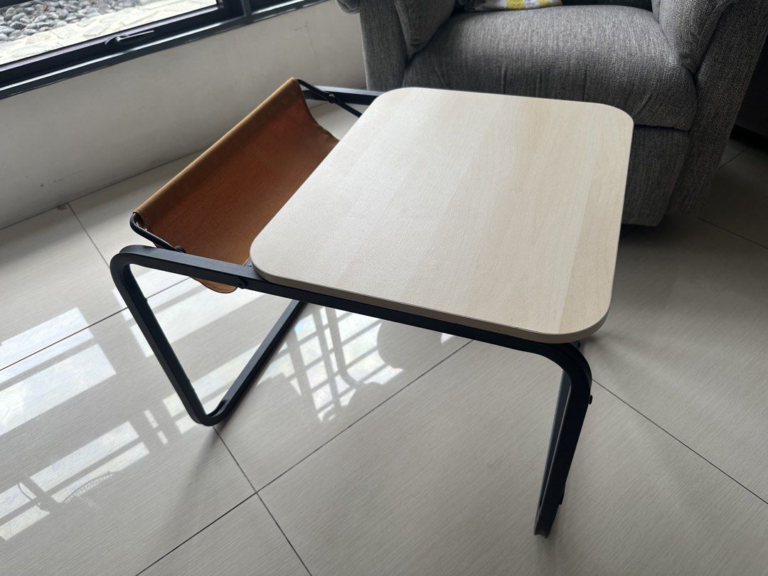 IKEA OLSERÖD Side table / Laptop / coffee table dual height with catch tray (Category: Tables & Sets) located in Quezon City. Submitted by dlsy12 (Listing ID 1467930624, Image 1). Description: - Compact accent table with a stylish light wood-grain top and sturdy black metal frame - Features a built-in brown fabric sling pocket at the back for storing magazines and small items - Ideal for small spaces in the living room, bedroom, or study area - C