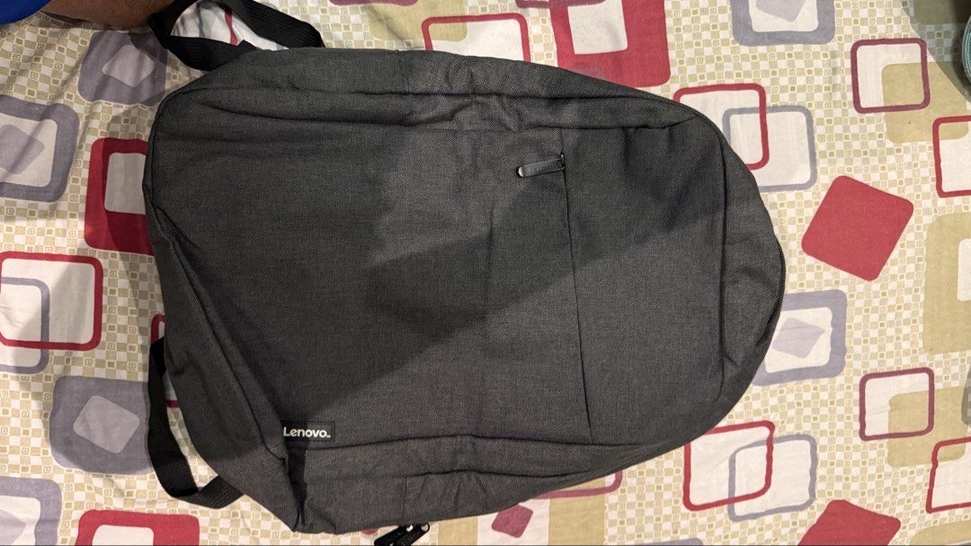 Lenovo Grey Casual Laptop Backpack (Category: Backpacks) located in Quezon City. Submitted by kobeeeee_12 (Listing ID 1467845475, Image 3). Description: - Brand/Model: Lenovo grey backpack in clean dark fabric - Storage: Front zippered pocket for quick access to essentials - Comfort: Adjustable shoulder straps and padded back panel - Portability: Convenient top grab handle - Design: Minimalist branding tag near the bottom corner - Condition: Exce