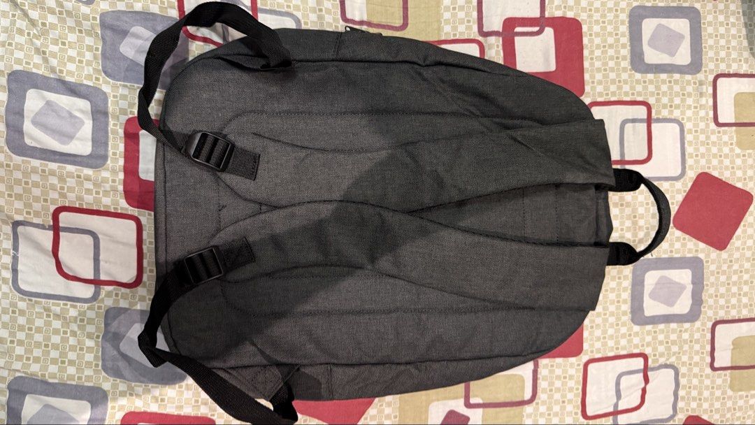 Lenovo Grey Casual Laptop Backpack (Category: Backpacks) located in Quezon City. Submitted by kobeeeee_12 (Listing ID 1467845475, Image 2). Description: - Brand/Model: Lenovo grey backpack in clean dark fabric - Storage: Front zippered pocket for quick access to essentials - Comfort: Adjustable shoulder straps and padded back panel - Portability: Convenient top grab handle - Design: Minimalist branding tag near the bottom corner - Condition: Exce