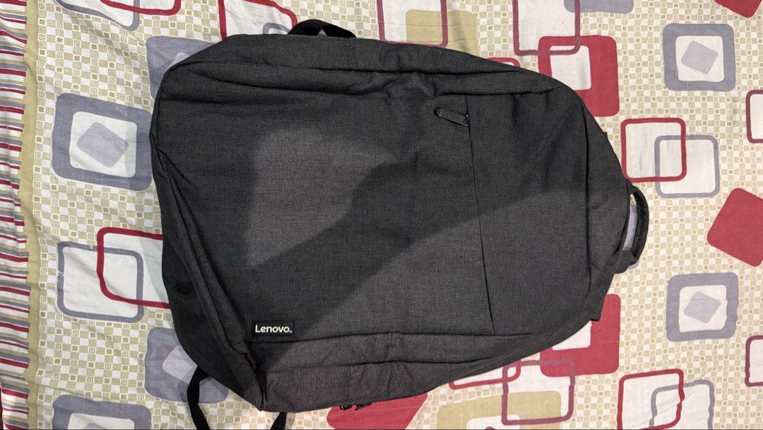 Lenovo Grey Casual Laptop Backpack (Category: Backpacks) located in Quezon City. Submitted by kobeeeee_12 (Listing ID 1467845475, Image 1). Description: - Brand/Model: Lenovo grey backpack in clean dark fabric - Storage: Front zippered pocket for quick access to essentials - Comfort: Adjustable shoulder straps and padded back panel - Portability: Convenient top grab handle - Design: Minimalist branding tag near the bottom corner - Condition: Exce
