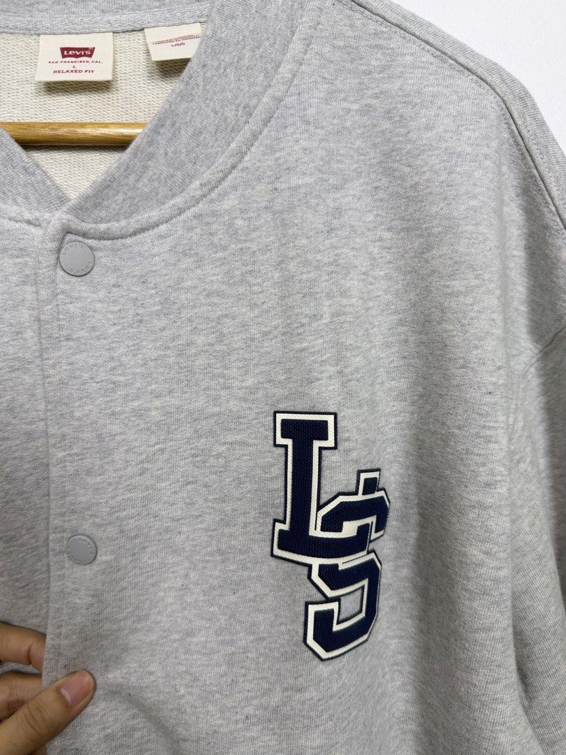 Levi's Bomber Cardigan (Category: Coats, Jackets and Outerwear) located in Silang. Submitted by estilocavph (Listing ID 1467942092, Image 3). Description: - Brand: Levi's - Item: Bomber Cardigan - Color: Grey with contrast navy blue LS varsity patch - Size: Large (Relaxed fit) - Closure: Snap button front - Pockets: Dual front pockets - Details: Ribbed cuffs, collar, and hem - Condition: Brand new with original paper tag attached Dimensions: L30.