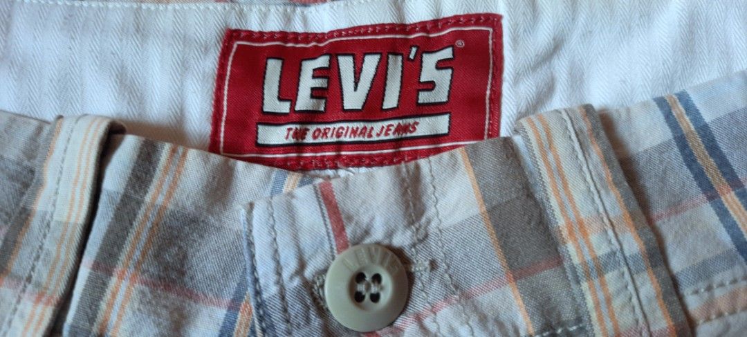 Levi's Plaid Flat Front Shorts W31 (Category: Shorts) located in Manila. Submitted by declutter.mnla (Listing ID 1467890270, Image 3). Description: - Brand: Levi's - Style: Plaid flat front casual shorts - Colorway: Beige, blue, and orange tones - Size: W31 - Material: 100% cotton (Made in India) - Closure: Button fly - Pockets: Two back flap pockets with button details and Levi's logo tag - Condition: Great for warm weather days and daily wear.