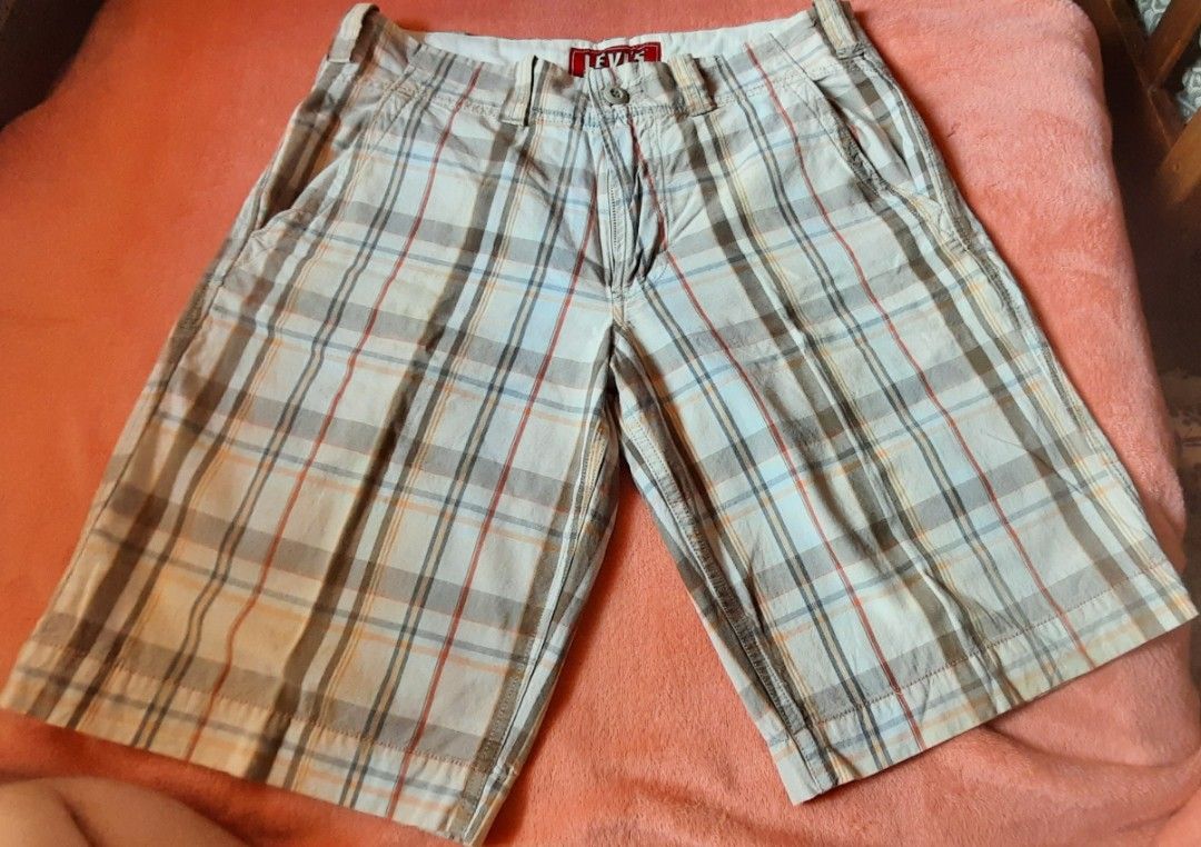 Levi's Plaid Flat Front Shorts W31 (Category: Shorts) located in Manila. Submitted by declutter.mnla (Listing ID 1467890270, Image 1). Description: - Brand: Levi's - Style: Plaid flat front casual shorts - Colorway: Beige, blue, and orange tones - Size: W31 - Material: 100% cotton (Made in India) - Closure: Button fly - Pockets: Two back flap pockets with button details and Levi's logo tag - Condition: Great for warm weather days and daily wear.