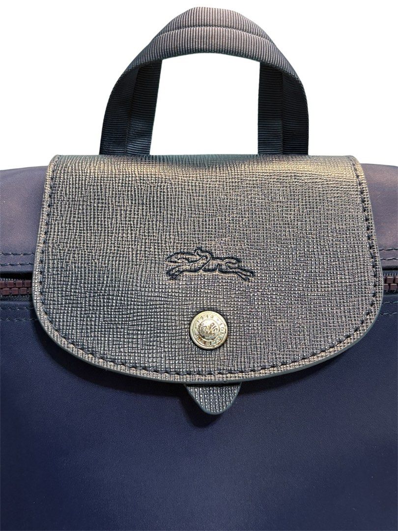 Longchamp Le Pliage Backpack Navy Blue (Category: Backpacks) located in Cagayan de Oro. Submitted by thatsdopethrift (Listing ID 1467881734, Image 3). Description: The bag features water-resistant recycled nylon canvas and matching leather trim. Please note that the round metallic jockey pull charm is missing from the slider loop, but the zipper mechanism remains fully smooth and operational. • Base Width: 10.2 inches (26 cm) • Height: 11.0 inche