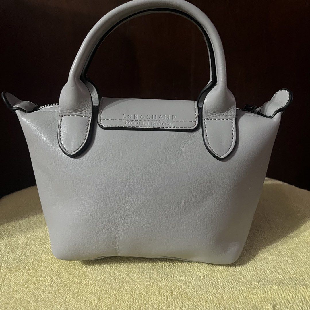 Longchamp Le Pliage Cuir Extra Small Top Handle Bag (Category: Luxury Bags & Wallets) located in Manila. Submitted by pickandgo26 (Listing ID 1467862286, Image 3). Description: Condition: Compact size with minor scuff on one handle edge and a small scratch at the back, missing sling. With jelly tag inside. Not guaranteed. Still nego Pls see actual photos for reference..
