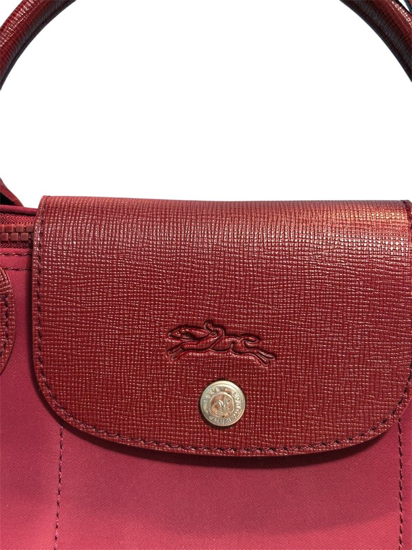 LONGCHAMP Le Pliage Néo Top Handle Bag (Category: Shoulder Bags) located in Cagayan de Oro. Submitted by thatsdopethrift (Listing ID 1467880622, Image 3). Description: Authentic Longchamp Le Pliage Néo small top handle bag in Opera Red. Includes a detachable wide crossbody webbing strap for versatile styling. Condition: Good pre-owned condition. Shows minor scuffing/wear on the bottom corners and a small snag on the lower nylon body as pictured. 