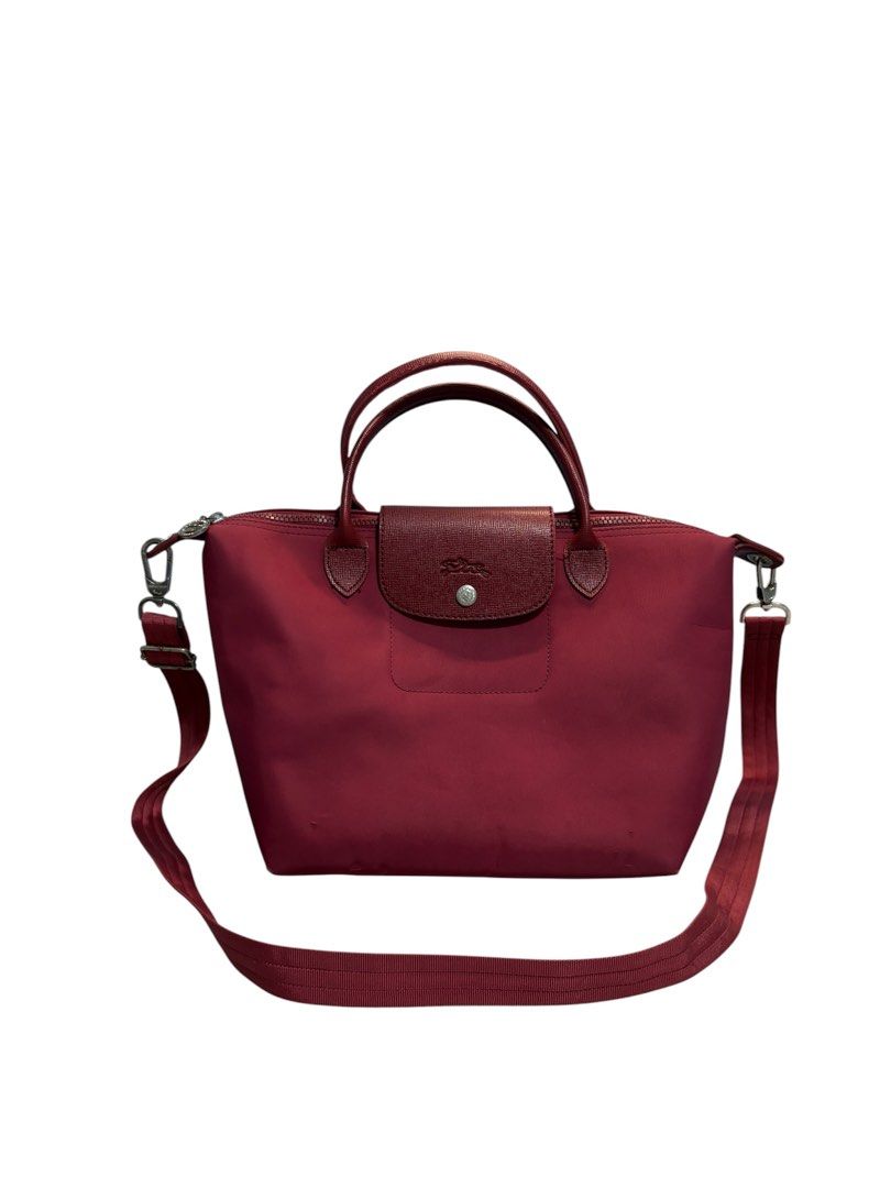 LONGCHAMP Le Pliage Néo Top Handle Bag (Category: Shoulder Bags) located in Cagayan de Oro. Submitted by thatsdopethrift (Listing ID 1467880622, Image 2). Description: Authentic Longchamp Le Pliage Néo small top handle bag in Opera Red. Includes a detachable wide crossbody webbing strap for versatile styling. Condition: Good pre-owned condition. Shows minor scuffing/wear on the bottom corners and a small snag on the lower nylon body as pictured. 