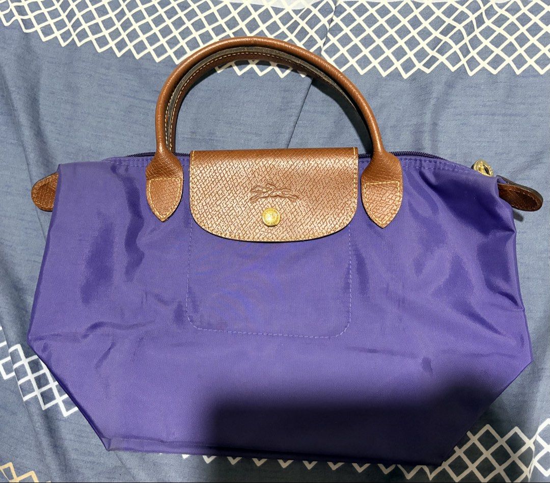 Longchamp Le Pliage Purple Handbag Small Short Handle (Category: Luxury Bags & Wallets) located in Quezon City. Submitted by pattycloset08 (Listing ID 1467965856, Image 1). Description: - Authentic Longchamp Le Pliage Handbag (Size S) - Color: Purple with signature brown leather trim - Hardware: Gold-tone - Closure: Zip top with snap button flap - Features: Short handles, lightweight foldable nylon fabric - Condition: Well-maintained with clean c