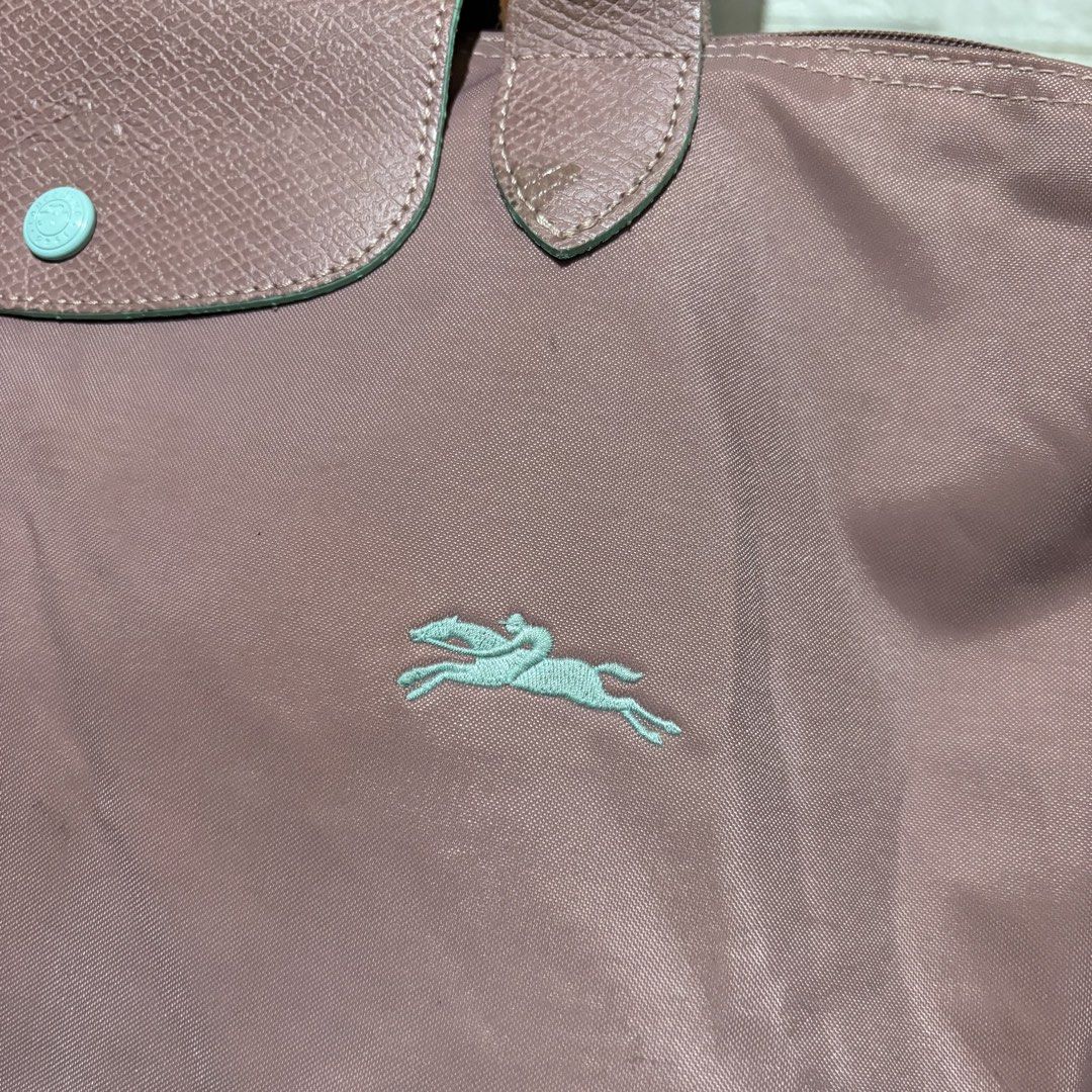 Longchamp Pink Tote Bag (Category: Tote Bags) located in Carmen. Submitted by rr_thrifts (Listing ID 1467931891, Image 2). Description: - Brand: Longchamp - Style: Nylon Tote Bag - Color: Pink with mint green contrast trim and matching embroidered horse logo - Closure: Front flap with snap button - Straps: Double shoulder straps.