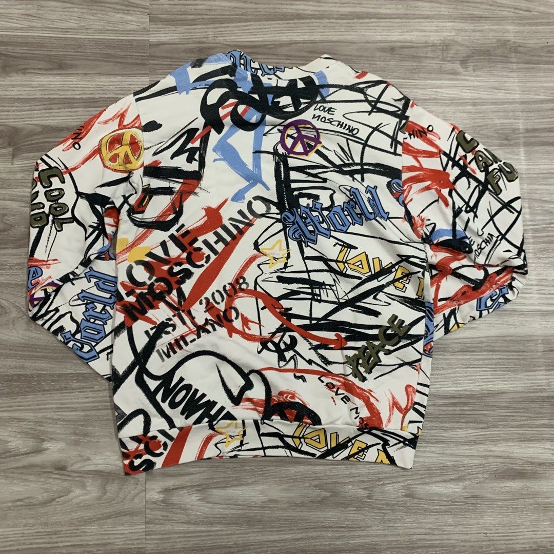 Love Moschino Graffiti Print Sweatshirt (Category: Longsleeves) located in Cavite. Submitted by yobubsss (Listing ID 1468050283, Image 3). Description: - Brand: Love Moschino - Color: White with vibrant all-over graffiti print (FUTURE, LOVE MOSCHINO, peace signs) - Size: Small (neck tag attached) - Material: Soft cotton blend - Details: Long sleeves, ribbed cuffs and hem, inner care label included - Condition: Brand new with tags.