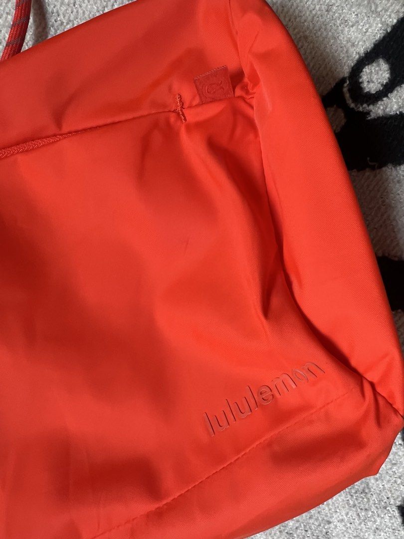 Lululemon Convertible Sling Backpack Red Orange (Category: Backpacks) located in Cagayan de Oro. Submitted by nelsondel21723 (Listing ID 1467884458, Image 2). Description: - Authentic Lululemon convertible sling bag and backpack in a vibrant red-orange shade - Crafted from durable, water-repellent nylon material with a clean interior and exterior - Versatile drawstring rope straps equipped with adjustable padded shoulder pieces - Convenient zippe
