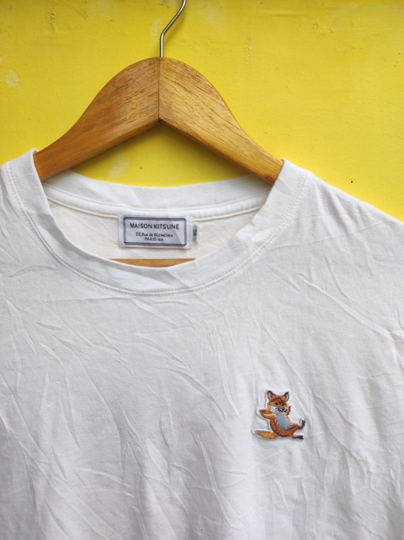 Maison Kitsuné White Fox Patch T-Shirt (Category: Shirts) located in Cuartero. Submitted by tripthriftfinds (Listing ID 1467879757, Image 2). Description: - Brand: Maison Kitsuné - Color: White - Size: XS - Material: 100% Cotton (Made in Portugal) - Design: Iconic sitting fox patch on chest, classic crew neck, short sleeves - Condition: Clean piece with solid collar and cuffs; has minor storage wrinkling and needs a quick iron.