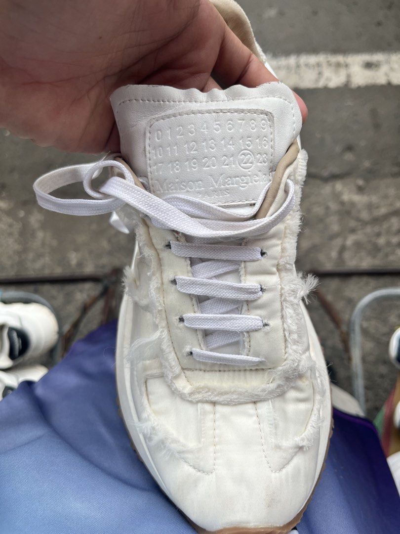 Maison Margiela Retro Runner White Sneakers (Category: Sneakers) located in Manila. Submitted by jj_thrift (Listing ID 1467949418, Image 3). Description: - Brand: Maison Margiela - Model: Retro Runner Sneakers - Color: White - Upper: Quilted nylon with raw frayed edges and leather accents - Sole: Heavy-traction gum rubber lug sole - Details: Branded tongue patch, embossed numeric branding at the heel wrap, white lace-up closure - Style: Clean aes