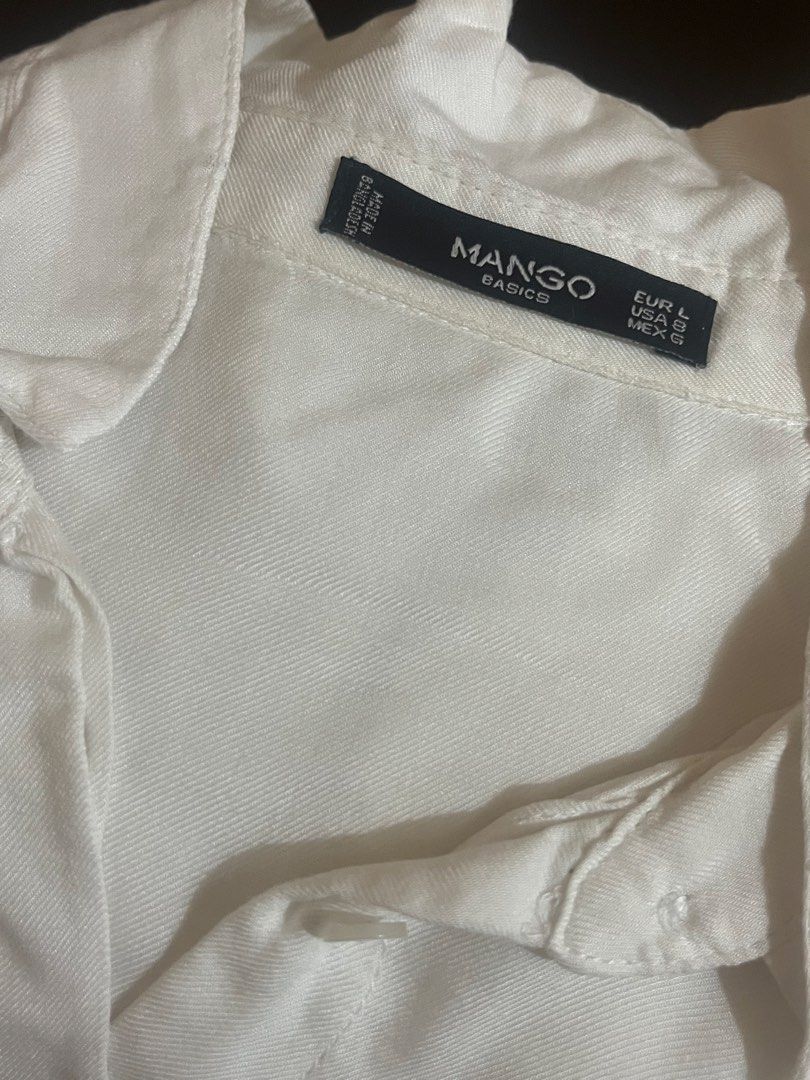 Mango Basics White Button-Down Shirt (Category: Shirts) located in Binan City. Submitted by hannahbanana928 (Listing ID 1467993851, Image 3). Description: - Brand: Mango Basics - Color: White - Size: EUR L, USA 8, MEX G - Style: Classic collar, long sleeves, dual front chest pockets - Fabric: Light, slightly sheer - Origin: Made in Bangladesh - Condition: Good, with a small faint mark near the right pocket area (shown in photos) - Versatile class