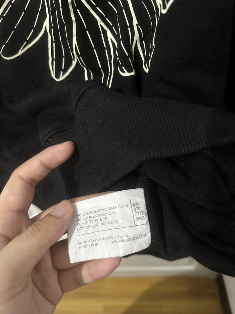 Mardi Mercredi Black Sweatshirt (Category: Coats, Jackets and Outerwear) located in Manila. Submitted by driftthrift (Listing ID 1467894625, Image 3). Description: - Brand: Mardi Mercredi - Color: Black with iconic floral graphic and white lettering - Material: 100% Cotton - Origin: Made in Seoul, South Korea - Fit: Standard fit with comfortable crewneck, ribbed cuffs, and hem - Condition: Brand new / Excellent quality.