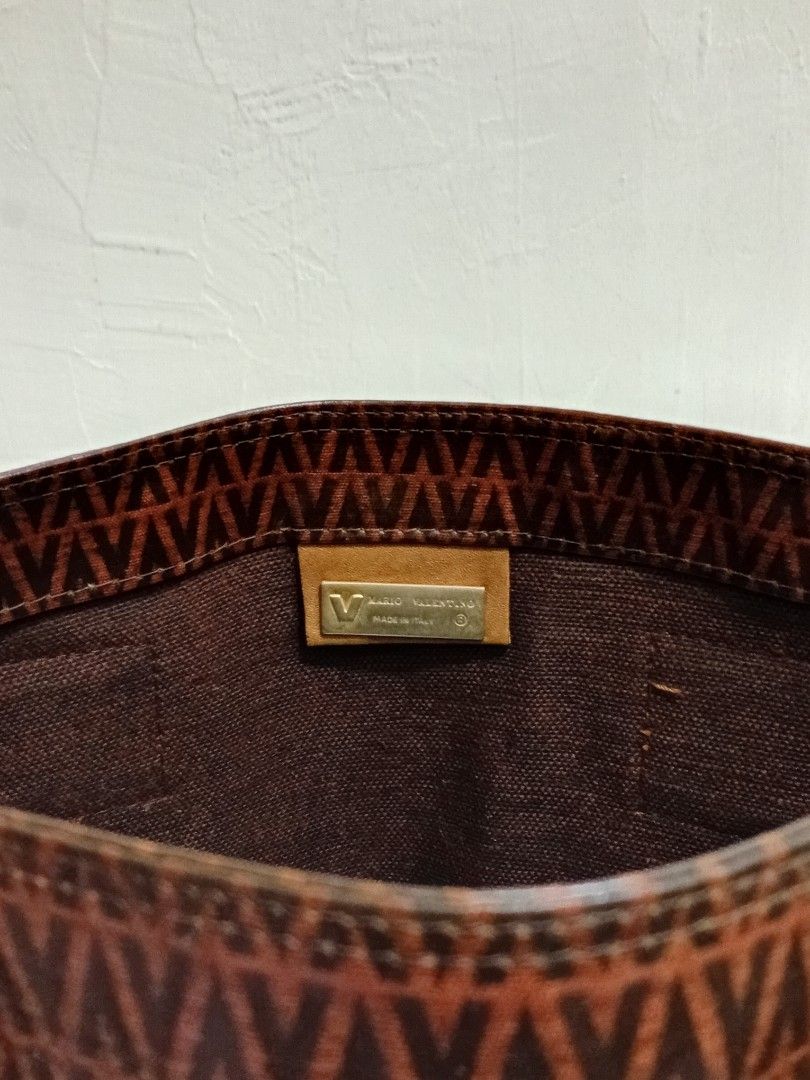 Mario Valentino Monogram Brown Tote Bag (Category: Luxury Bags & Wallets) located in Manila. Submitted by eriiicaspage (Listing ID 1467882345, Image 3). Description: PreOwned Lightly Used Authentic Mario Valentino brown tote bag with classic repeating V monogram pattern - Made in Italy with structured shape that holds up very well - Features comfortable double fabric shoulder straps with minor wear - Convenient exterior slip pocket for quick acce