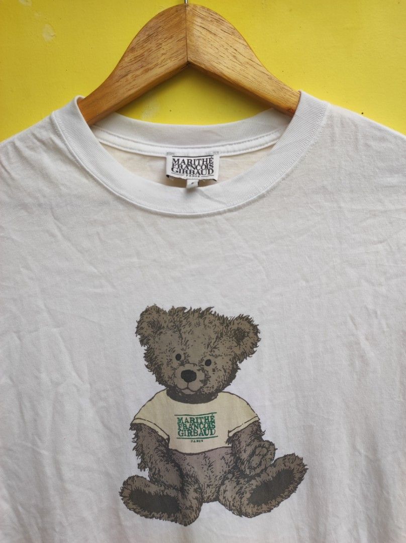 Marithe Francois Girbaud White Bear T-shirt Size S (Category: Shirts) located in Cuartero. Submitted by tripthriftfinds (Listing ID 1467879613, Image 3). Description: - Brand: Marithe Francois Girbaud (Paris brand) - Color: Classic White - Size: S (tag at collar) - Design: Front graphic of a teddy bear wearing a branded top - Details: Short sleeves, crew neckline, care label inside - Condition: Pre-loved, well-maintained - Style: Casual, easy to 